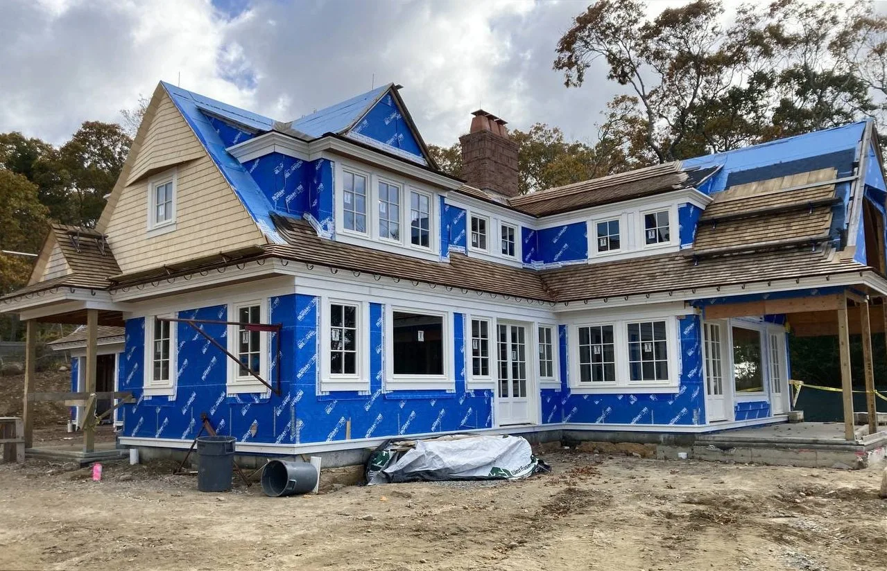 House elevation wrapped in blue housewrap before the cedar went on